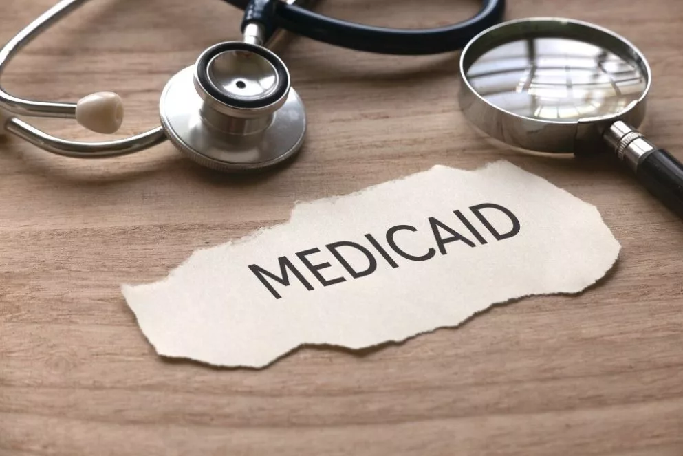 Selective focus of stethoscope magnifying glass and piece of paper written with medicaid on wooden t20 dr Q Wp R
